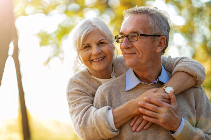 senior couple outdoors wearing beige sweaters