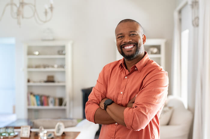 middle-aged man with arms crossed and smiling